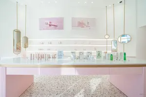 골드 미러와 화이트 선반이 어우러진 화장품 진열 공간